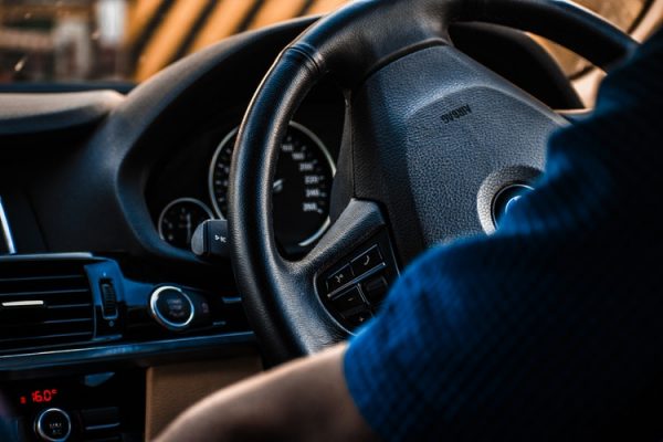 Driver's perspective of a steering wheel and dashboard inside a car.